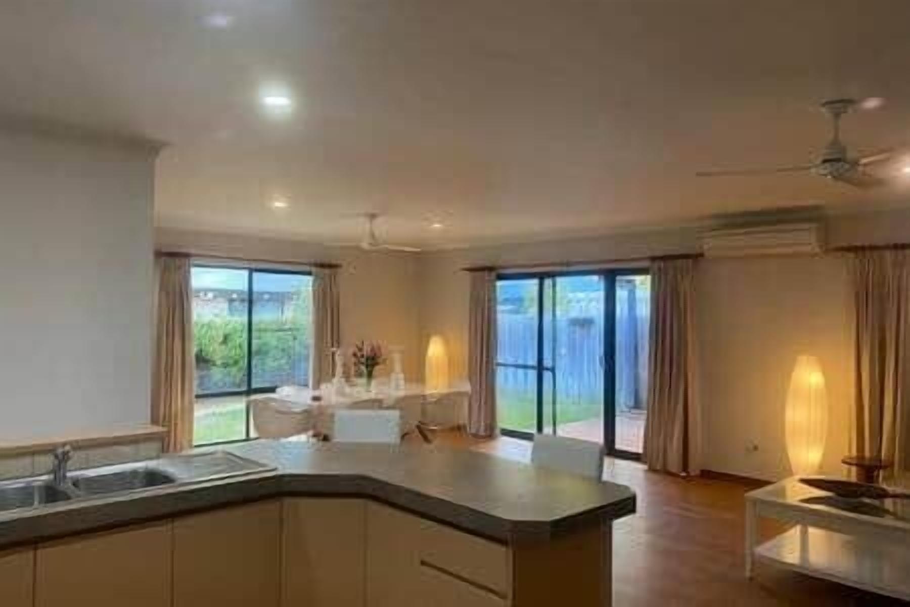 Una cocina moderna con una isla central, ventanas amplias y vistas al exterior.