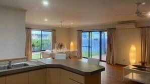A modern kitchen with a central island, large windows, and a view of the outdoors.