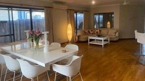 A spacious living area with a dining table and chairs, a sofa, and a coffee table.