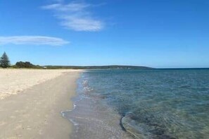 Een strand met helder water en een zandstrand.