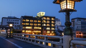 A traditional Japanese building with multiple floors and a sign in Japanese. - Ohashikan (Matsue)