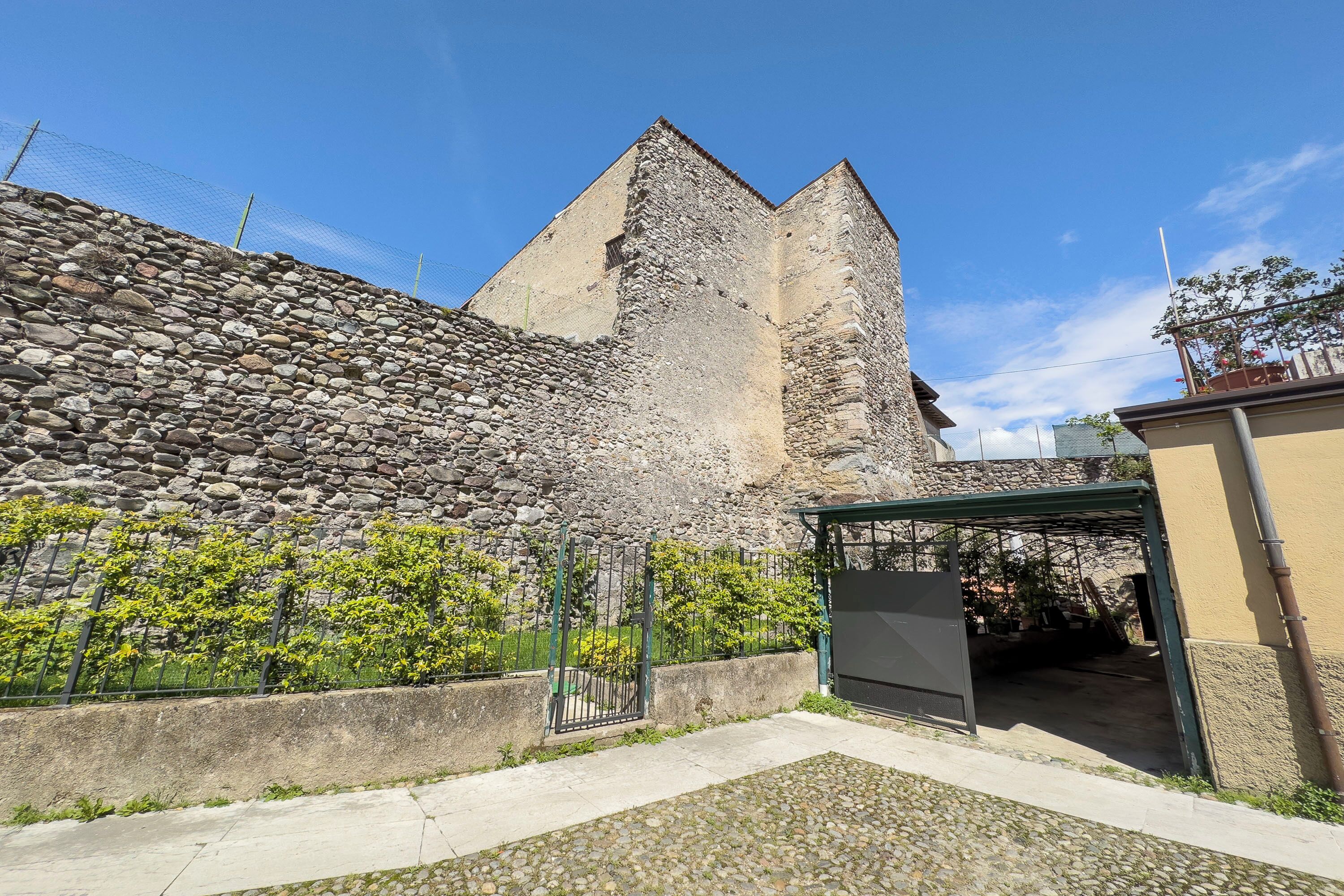Edifici de pedra amb una reixa metàl·lica i un vestíbul cobert.