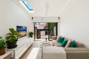Een moderne woonkamer met een bank, een salontafel en uitzicht op buiten.