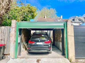Un coche estacionado dentro de un garaje con techo verde.