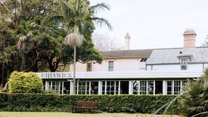Un edificio con un letrero que dice 'CHISWICK' y una banca en la parte delantera.