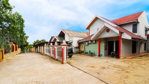 A street with houses, a paved road, and a parked motorcycle. - OYO 91607 Steze Guest House Syariah (Jambi)