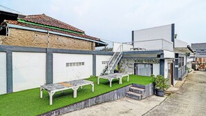 Een binnentuin met een klein zitgedeelte en een trap naar een gebouw.