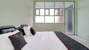 Een slaapkamer met een bed, een raam en een deur.