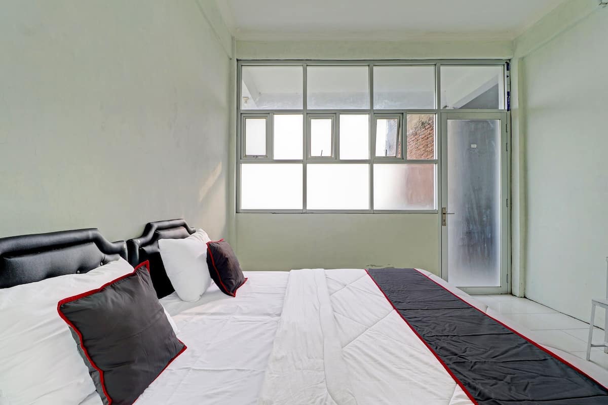 Une chambre à coucher avec un lit, une fenêtre et une porte.