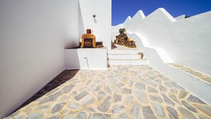 A narrow, white-walled corridor with a stone floor leading to a door with a keyhole. - CARTAMAR by Buenavilla | Refurbished villa with lots of outdoor space (Tías)