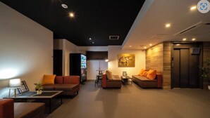 A modern living room with sofas, a coffee table, and a painting on the wall.