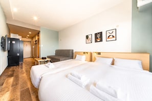 A hotel room with a large bed, a sofa, a small table, and a refrigerator. - WELLSTAY Osaka Shinimamiya (Osaka)