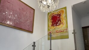 A staircase with glass railings and a chandelier above. - Casa-Palacio Santa Pola (Ronda)