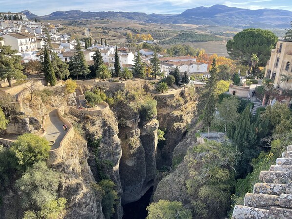 Un pueblo con un acantilado destacado y un camino serpenteante.
