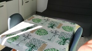 Ein kompakter Raum mit einem Bett, einem Schreibtisch mit Computer und einer Mikrowelle. An den Wänden befinden sich zwei Dekorationen mit Text.