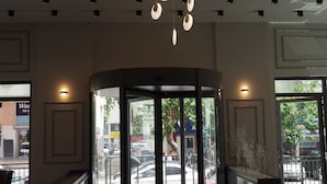 A lobby with a circular glass partition, a modern chandelier, and a reflection on the polished floor. - Zenia Otel (Antalya)