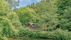 A cabin surrounded by dense forest and a pond. - A superbly appointed impressive two storey luxury lodge. (Llangollen)