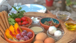 A wooden tray with various food items including fruits, eggs, and condiments. - Mayouli Nature Retreat (Batroun)