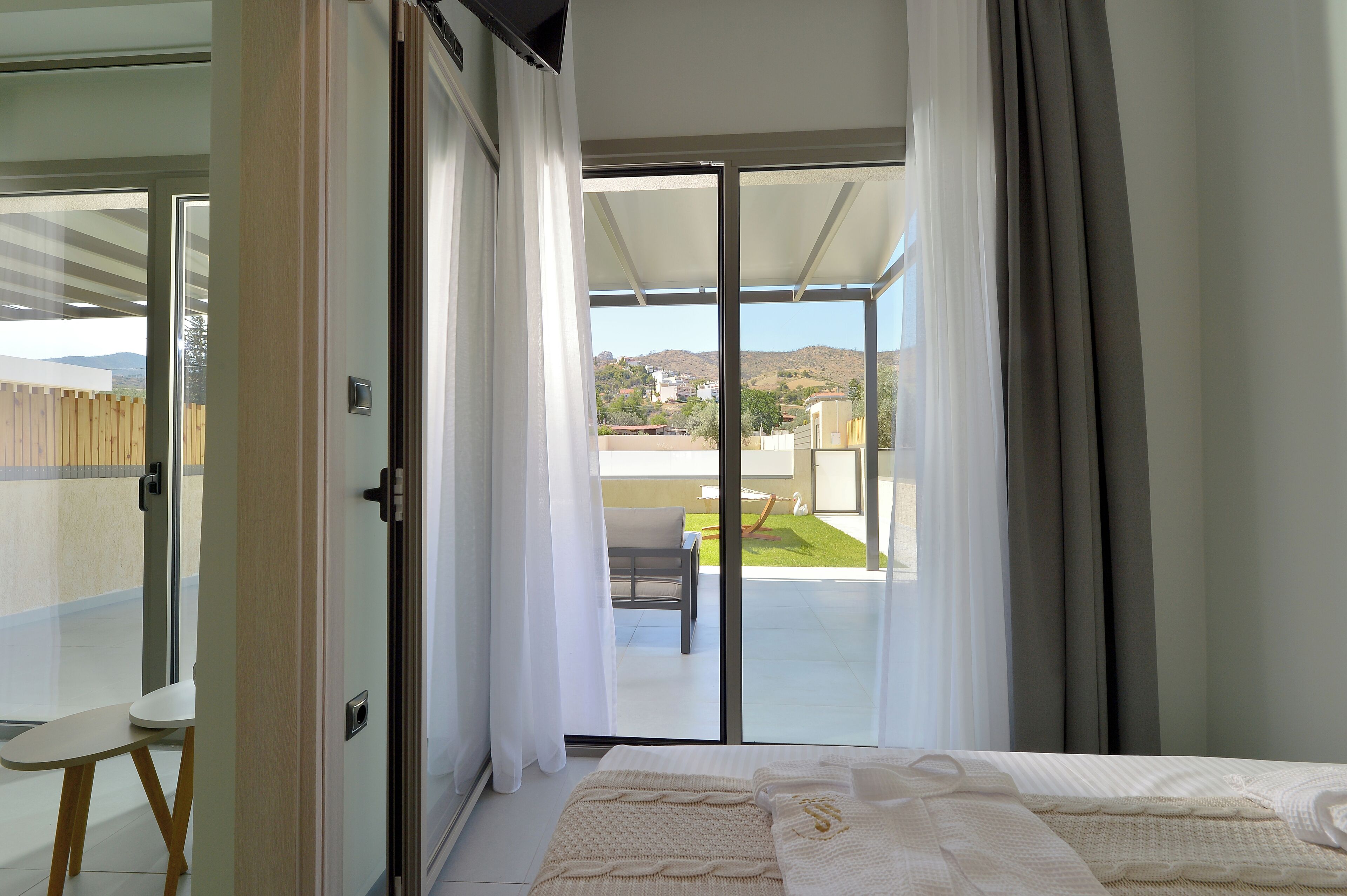 A bedroom with a large sliding glass door leading to a balcony.
