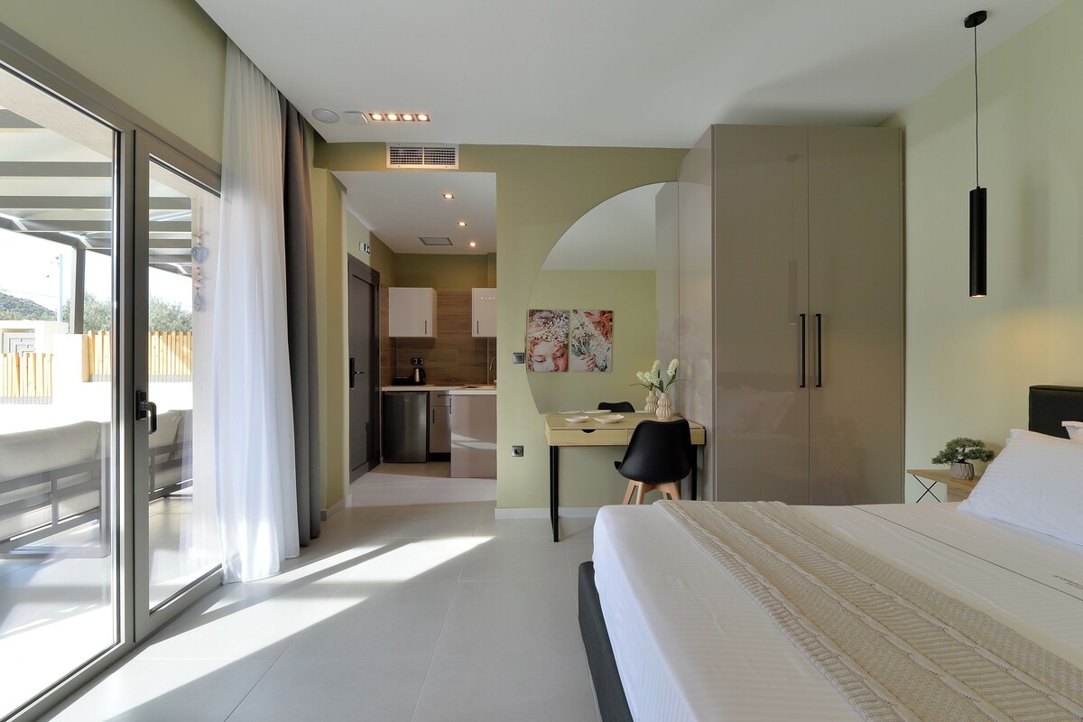 Une chambre d’hôtel moderne avec un grand lit, un bureau et une vue sur le balcon extérieur.