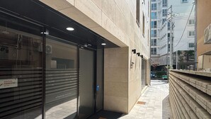 Un estrecho callejón con una tienda cerrada a la izquierda, un camino empedrado y un edificio con pared de ladrillo a la derecha.