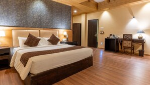 Un dormitorio con una cama grande, techo de madera y un escritorio con una silla.