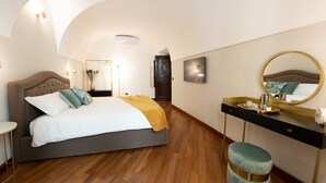 A bedroom with a bed, a vanity with a mirror, and a small stool. - The Best Rent - Deluxe Piazza di Spagna Apartment (Roma)