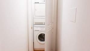 A laundry room with a front-loading washing machine and a dryer. - The Best Rent - Deluxe Piazza di Spagna Apartment (Roma)