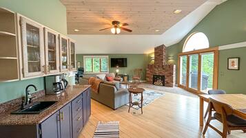 A spacious living area with a fireplace, a kitchen with a granite countertop, and a dining area with a table and chairs.