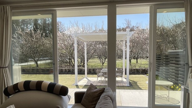 A modern living room with a large sliding glass door leading to an outdoor patio area. - Mt. Fuji koko wantyanOK sintikubessō (Fujikawaguchiko)