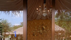 Una habitación con una cama, una araña y vistas al exterior.