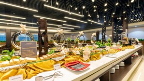 A buffet setup with various food items and decorative elements. - Horison Diana Timika (Timika)