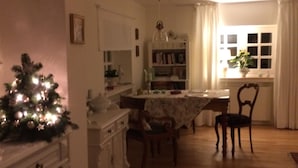 Ein gemütliches Wohnzimmer mit Essbereich, Kamin und Weihnachtstannenbaum.