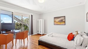 A modern bedroom with a large bed, a TV, and a balcony with a staircase. - Fremantle's Best | Urban Studio (Fremantle)