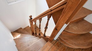 Una escalera de madera con barandilla y descansillo.