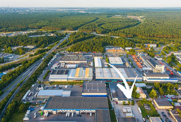 An industrial area with large buildings, parking lots, and roads. - Lollo Motel Graičiūno - Lollo Luxury (Vilnius)