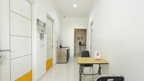 A corridor with a table and chairs, a sink, and cabinets. - OYO Life 3782 Gunung Anyar (Surabaya)