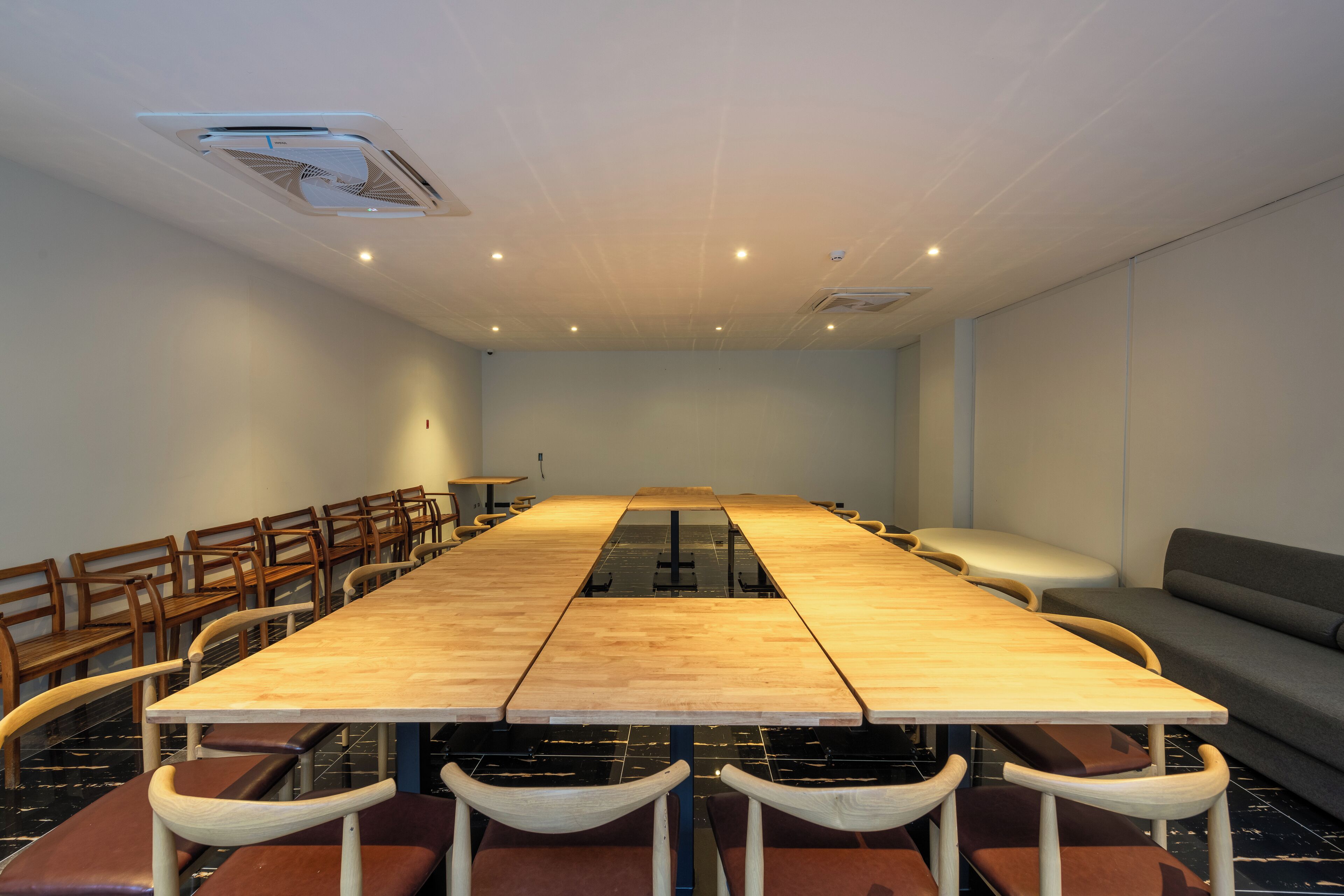 Une salle de conférence avec une longue table, des chaises et un canapé.