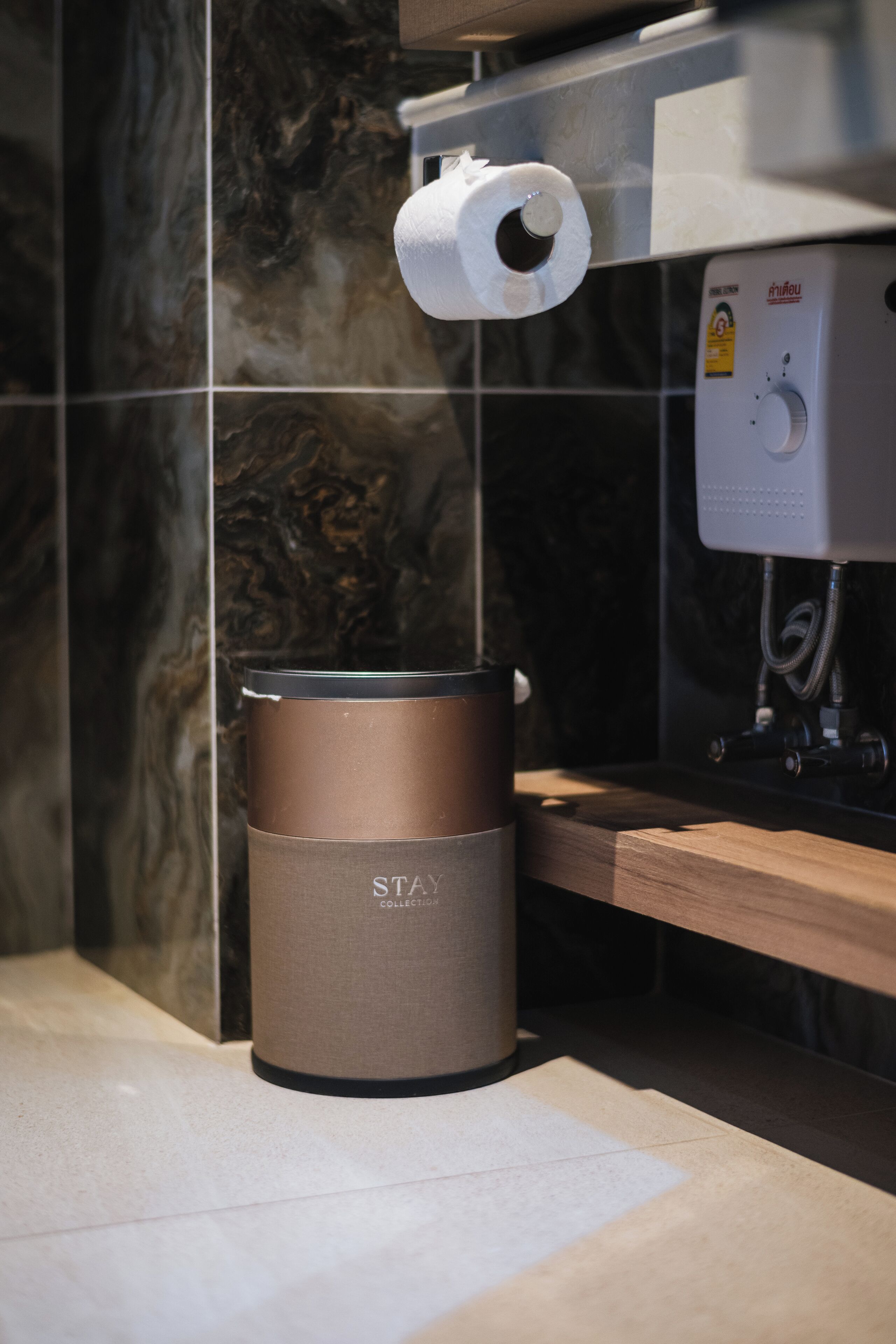 Une cuisine équipée d’une machine à café, d’un distributeur d’essuie-tout et d’une poubelle.