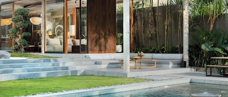 Une maison moderne dotée d’une piscine, d’un patio couvert et d’un jardin bien entretenu.