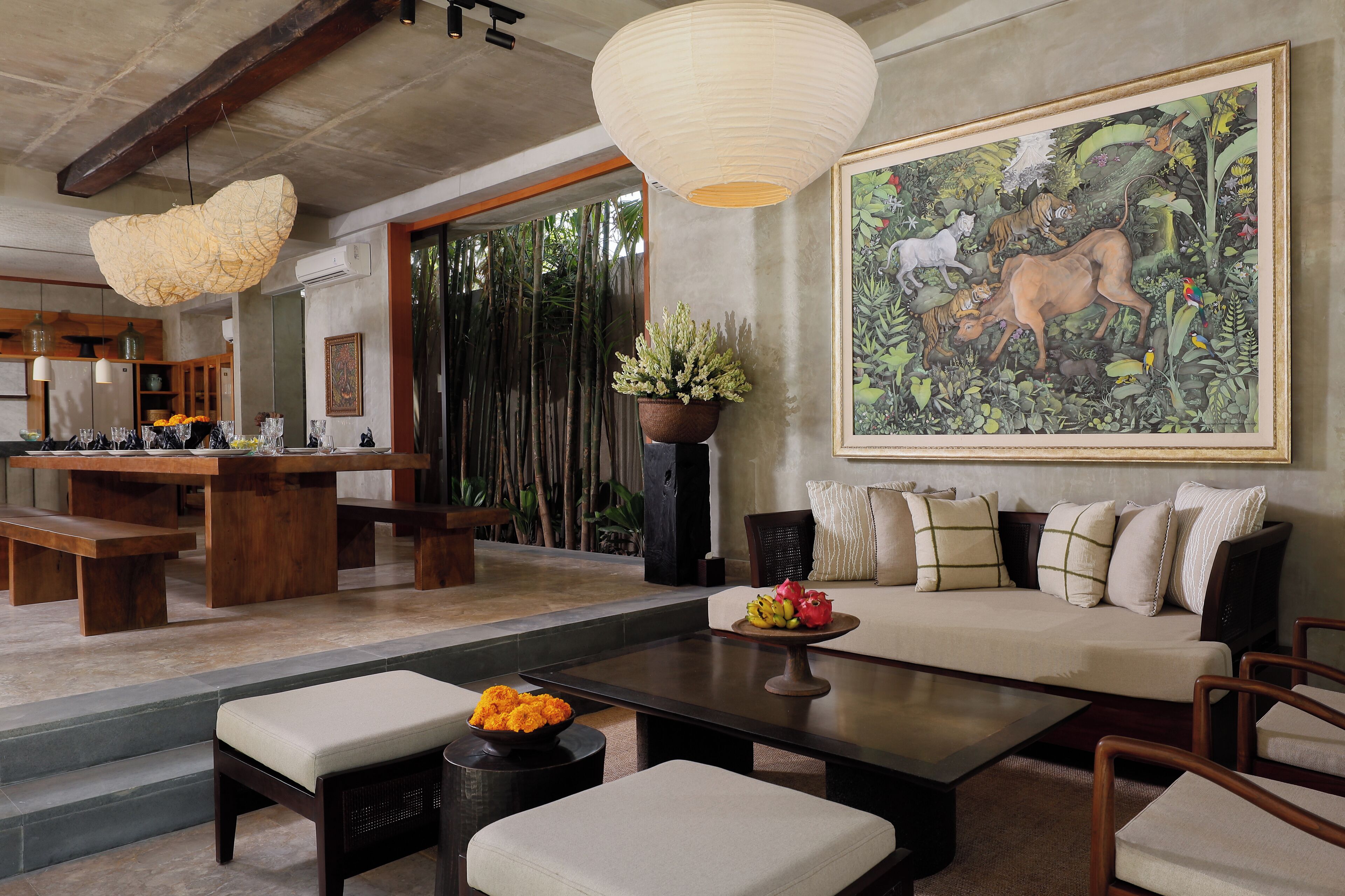 A spacious living area with a large painting, a dining table, and a sofa.