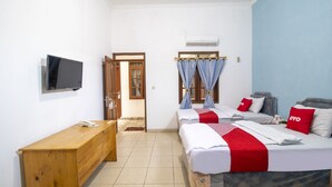 Camera da letto con due letti, una scrivania in legno, una TV e una finestra con tende.