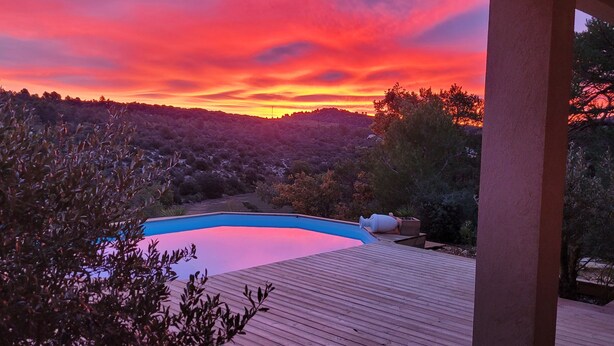 A wooden deck with a swimming pool, surrounded by dense vegetation and hills in the background. - T2 with swimming pool in the heart of the pines (Saint-Julien)