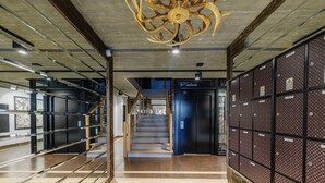 Ein modernes Interieur mit Treppe, einer dekorativen Deckenverzierung und einer Wand voller Staufächer.