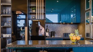 Eine moderne Küche mit Granit Arbeitsplatte, Edelstahlgeräten und einer Obstschale.
