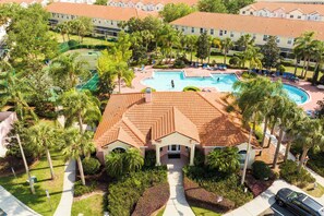 A hotel with a swimming pool, palm trees, and a red-tiled roof. - Stunning 3Bd Close to Disney at Fiesta Key 4764 (Kissimmee)