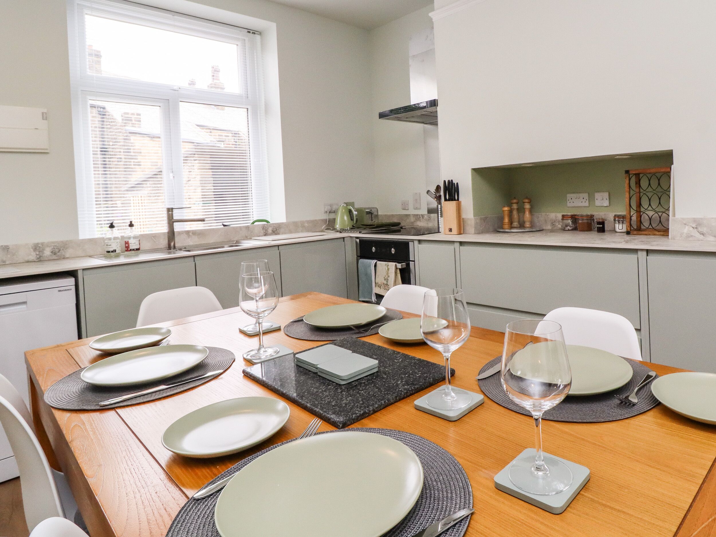 A modern kitchen with a dining area set for six.