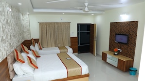 A hotel room with a large bed, a TV mounted on the wall, and a wooden cabinet. - Hotel 8th Mile Suites (Bengaluru)