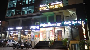 A hotel with multiple floors, executive rooms, and a visible entrance with steps. - Hotel 8th Mile Suites (Bengaluru)