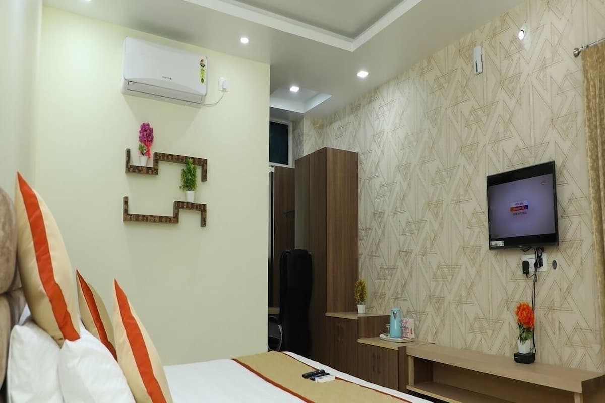 A hotel room with a bed, a TV, a desk, and a wardrobe.